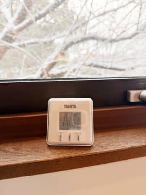 窓際に置いている温度計。時刻は8時28分温度21.1度湿度34％と表示されている。