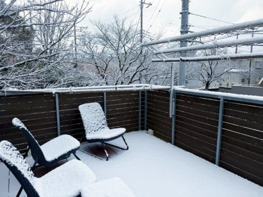 テラスのチェアや物干しに雪が積もっている様子。